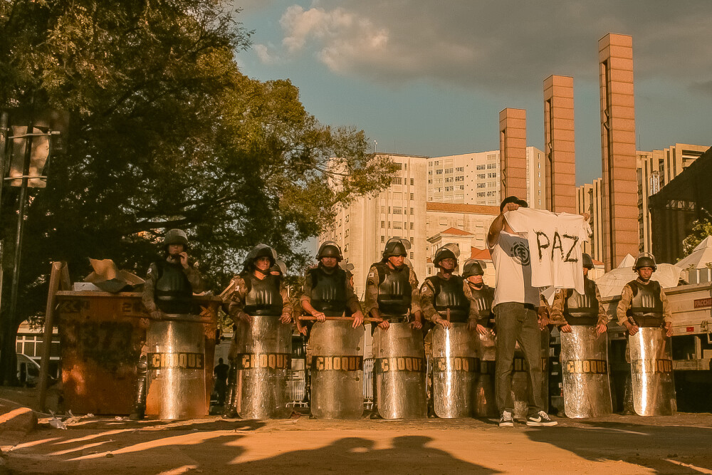 A atuação das polícias servem ao modelo de gestão da política. Na imagem, existe um manifestante em frente à policiais