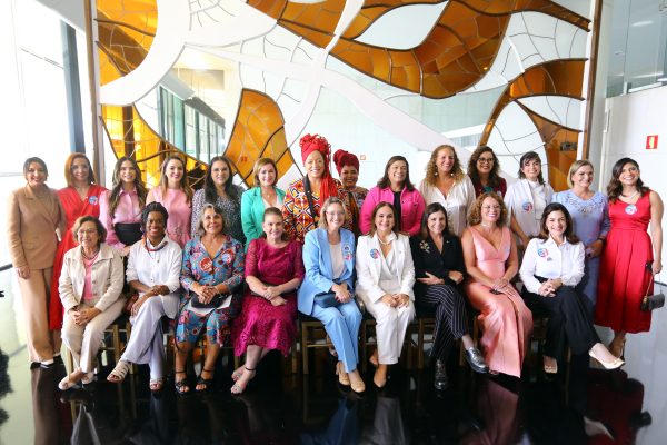 Deputadas da bancada feminina da Câmara dos Deputados em 2023 posam lado a lado em frente a um painel. Algumas estão sentadas e outras em pé atrás das cadeiras