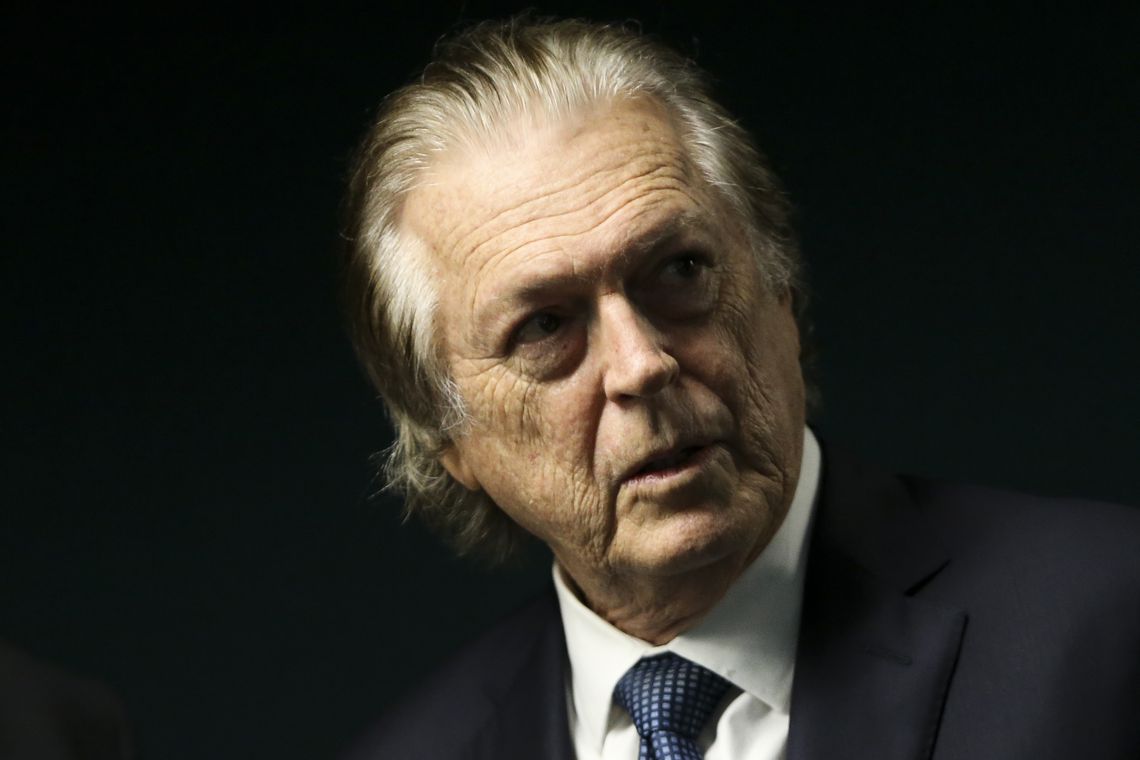 Luciano Bivar olha para o lado com semblante sério e de concentração.