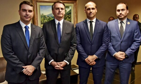 Jair Bolsonaro e seus três filhos mais velhos, em 2021. Eles usam terno escuro e estão lado a lado