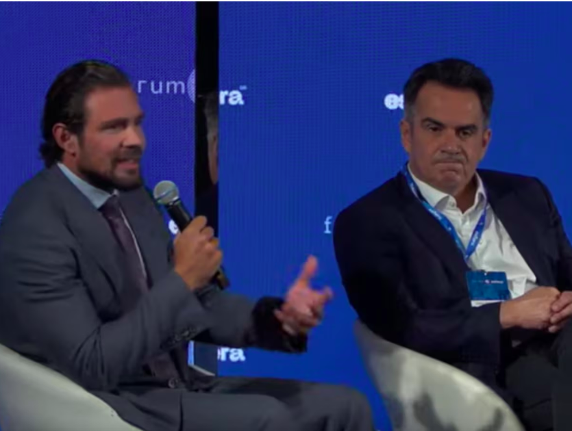 Daniel Vorcaro e Ciro Nogueira em evento da Esfera Brasil. Eles estão sentados lado a lado; Vorcaro fala em um microfone