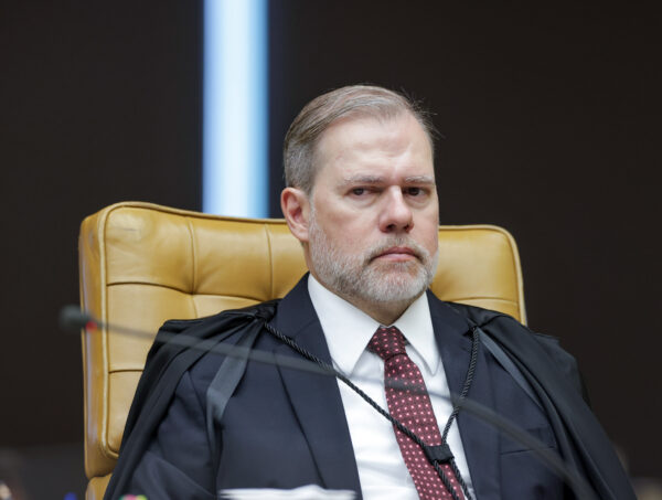 Dias Toffoli em sessão plenária o Supremo em 12 de fevereiro. Ele está sentado em uma poltrona bege, usa terno e gravata e está com a testa franzida