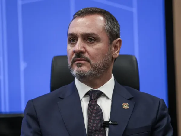 O diretor-geral da PF, Andrei Rodrigues. Ele usa camisa branca, terno azul e está sentado em uma cadeira