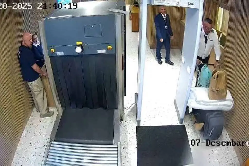 Imagem da câmera de segurança do Aeroporto Catarina, em São Roque (SP). Um homem passando ao lado de uma máquina de raio-x em um saguão