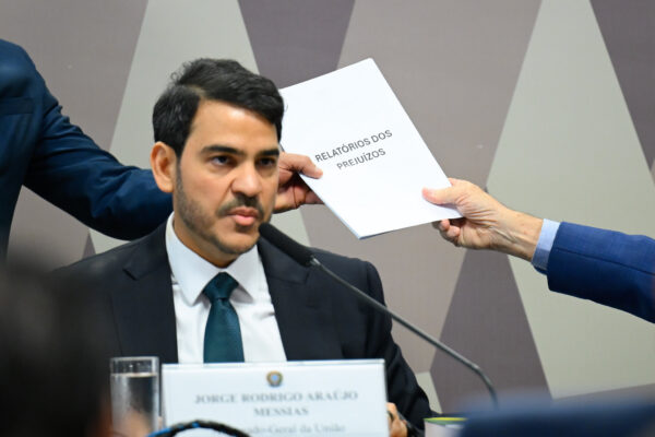 O advogado-geral da União, Jorge Messias, durante sabatina na CCJ do Senado. Ele é um homem branco, de barba e cabelos pretos, usar terno preto e camisa branca e está sentado falando em um microfone