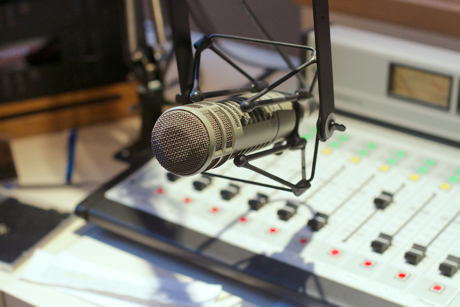 Estúdio de rádio. Imagem de um microfone e uma mesa de som